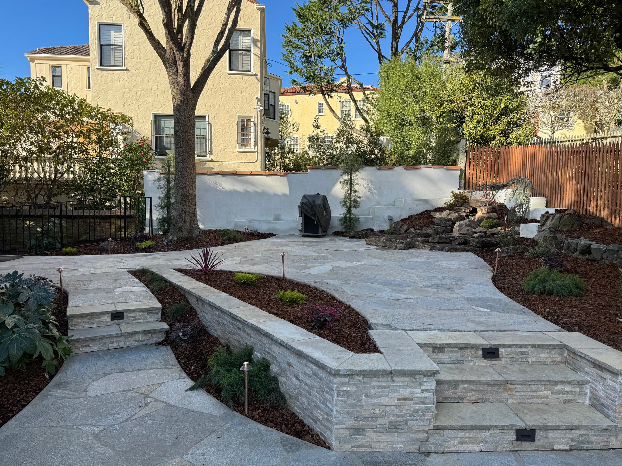 Backyard with quartzite patio, stairs, bench, waterfall, fence, lighting, & irrigation!
