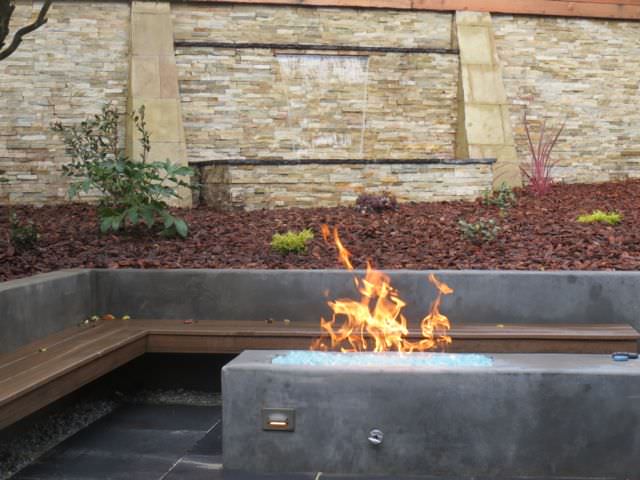 outdoor custom fireplace, custom waterfall, a redwood seating