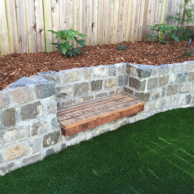 Redwood bench set in recycled cobblestone retaining wall