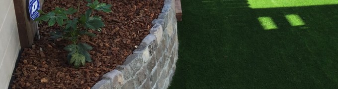 Artificial turf, retaining wall and mulch protected plants
