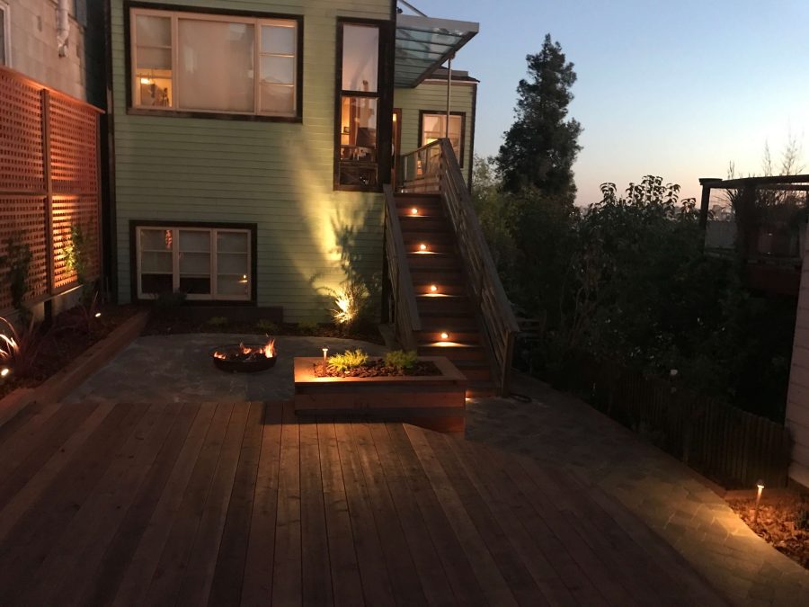 Backyard Landscape Project: After, at dawn: Framed redwood lattice screens the neighbor's wall, illuminated steps lead to the house while the natural gas firepit provides additional beauty to the landscape