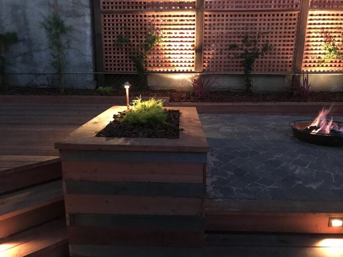 Backyard Landscape Project: Planter boxes made of new redwood with reclaimed onsite cedar, hold decorative plants and upright lighting