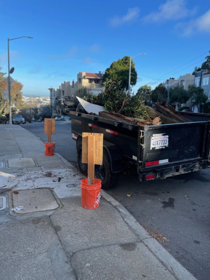 Trailer full of demo debris on street in front of client's house in Ashbury Heights.