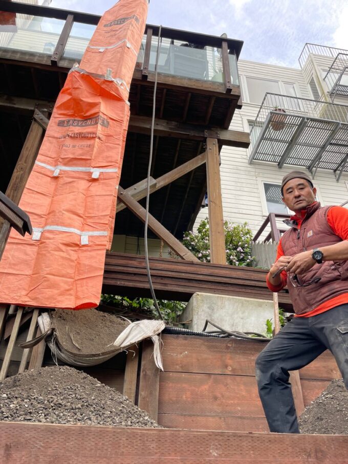 Paul standing next to Easy Chute used to transfer rock and sand to backyard from deck.