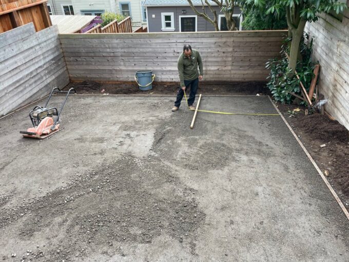 Paul measuring area of compacted base rock at Sunnyside, San Francisco project