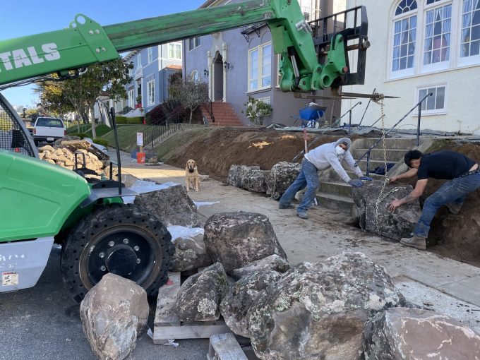 Positioning boulders with the aid of a forklift.