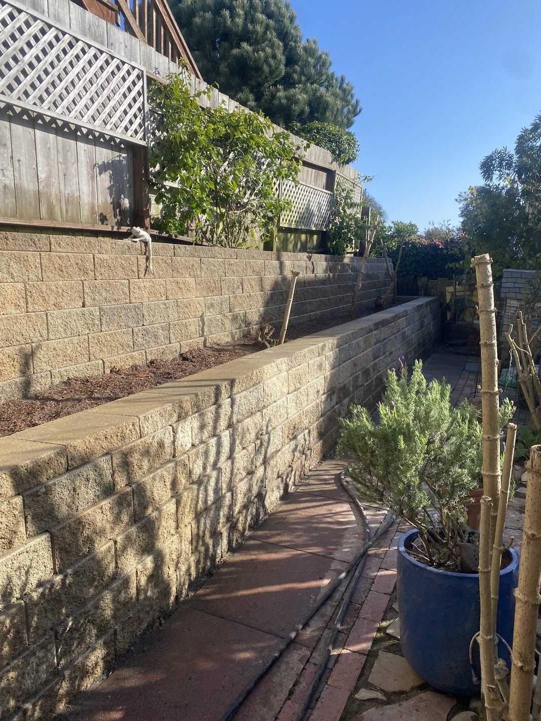 Completed two-tiered stone-colored VERSA-LOK retaining wall in West Portal, San Francisco. Top soil/compost in retaining wall terrace.