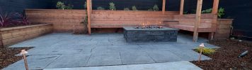 Completed redwood bench, pergola, and fire pit at our Outer Sunset, San Francisco project. Black basalt patio.