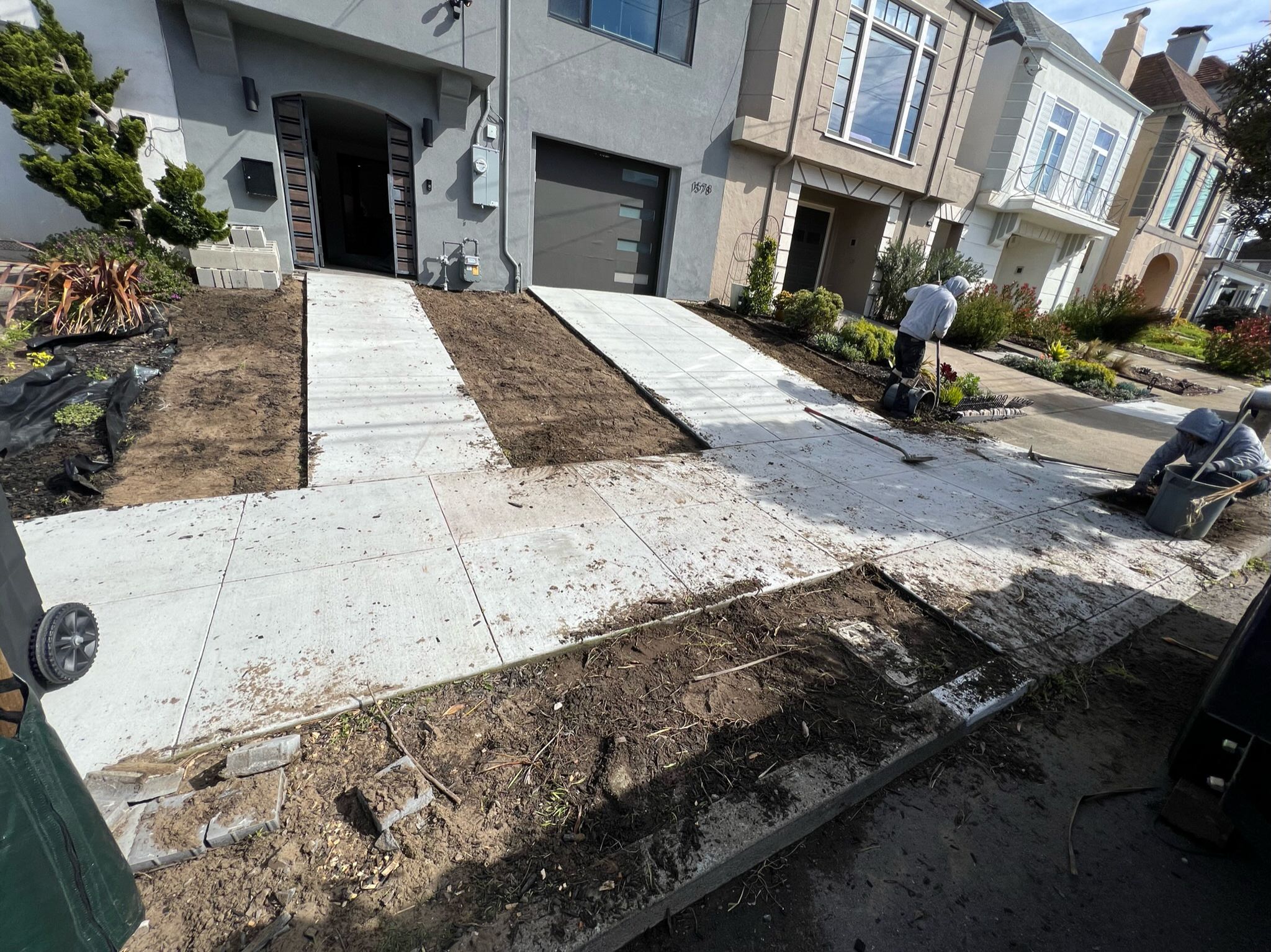 Front yard before at Outer Sunset, San Francisco project. Concrete walkway surrounded by two dirt areas on sides. Walkway in front of house with dirt area in front of walkway.