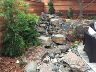 custom rock waterfall with a small recirculating water cascade in a boulder stream