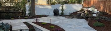 Backyard with quartzite patio, stairs, bench, waterfall, fence, lighting, & irrigation!