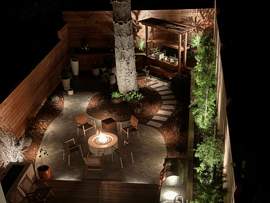 outdoor landscape lighting project featuring a custom firepit, uplighting, spotlights, and path lights